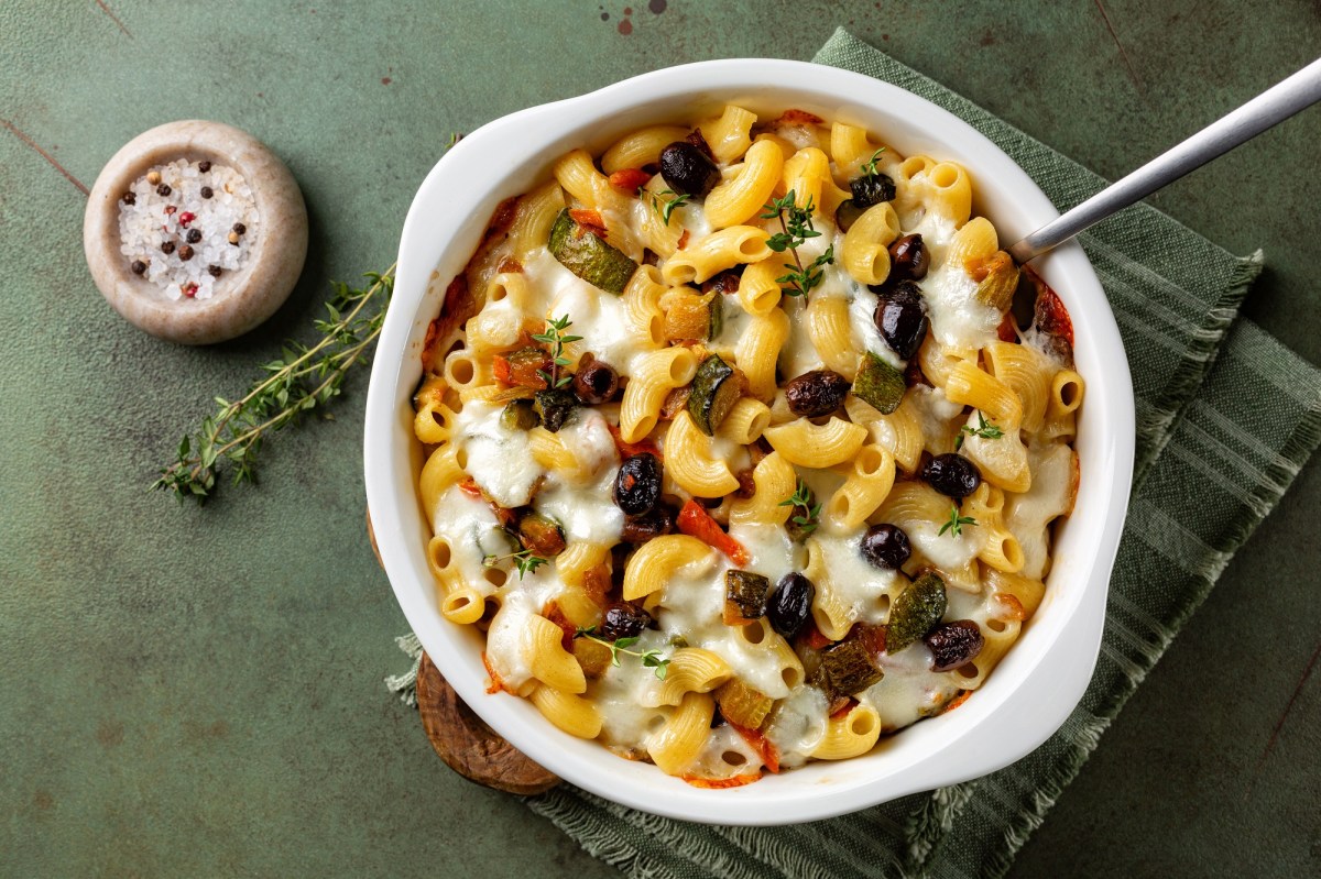 Mediterranean macaroni casserole in a white baking dish. Next to it is a pot of salt with peppercorns