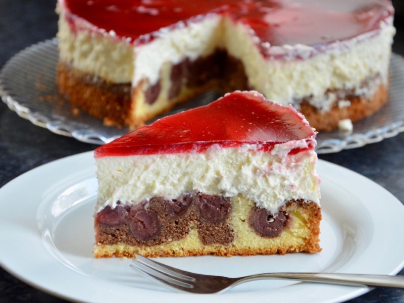 A piece of Little Red Riding Hood Cake on a plate. The rest of the cake is in the background.